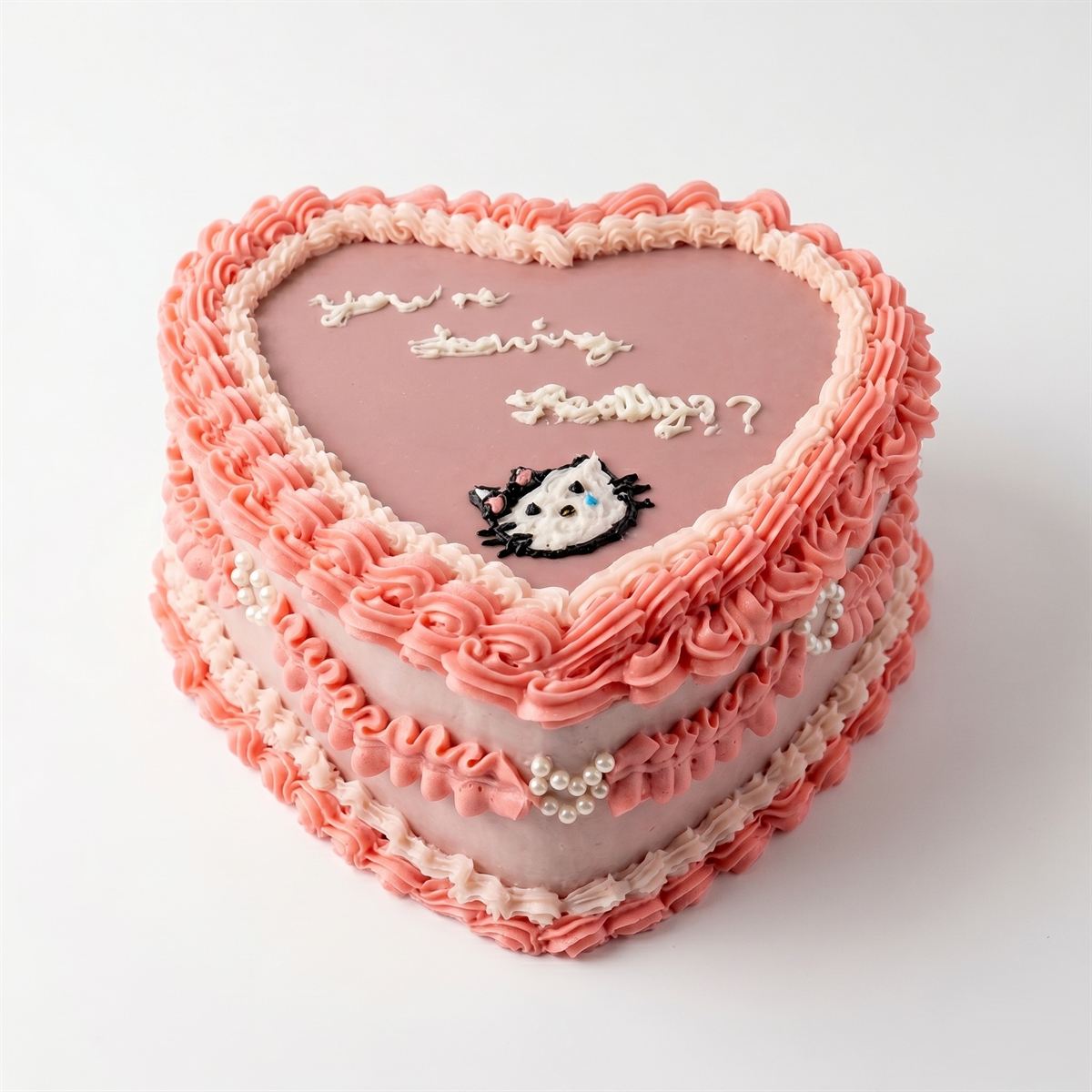 A pink vintage-style heart cake with ruffled buttercream piping and pearl details.